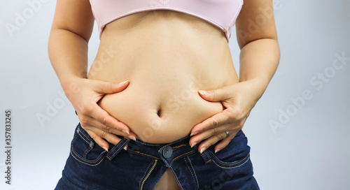 Diet Concept which Fat woman are worried about weight gain and she is Overweight and Trying To Fasten Trousers photo