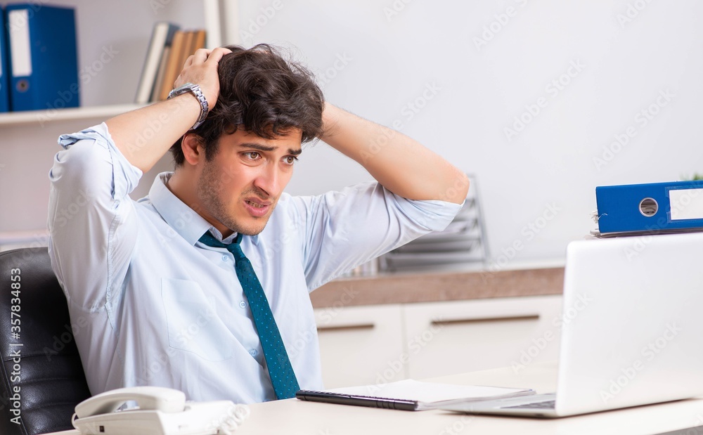 Overloaded busy employee with too much work and paperwork Overloaded busy employee with too much work and paperwork