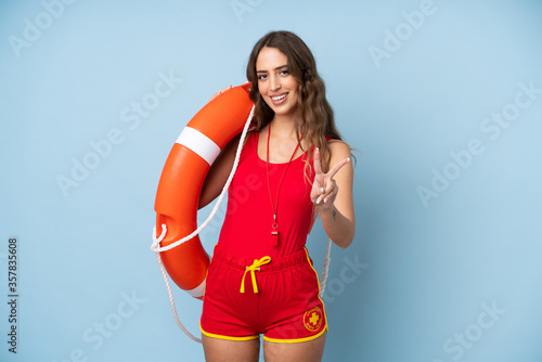 Young woman over isolated background with lifeguard equipment and doing victory sign