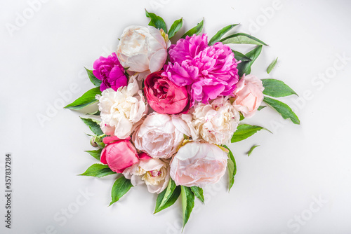 Flat lay of flowers and green leaves. Tender Peonies and chrysanthemums bloom pattern, composition for postcards on white background.