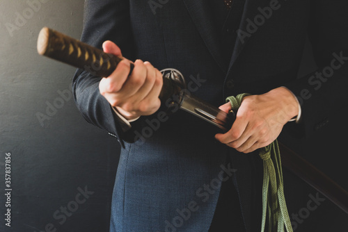 日本刀を携えたスーツの男性