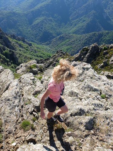 jeune femme blonde devant le vide de la montagne du Caroux au soleil couchant du parc naturel du haut languedoc