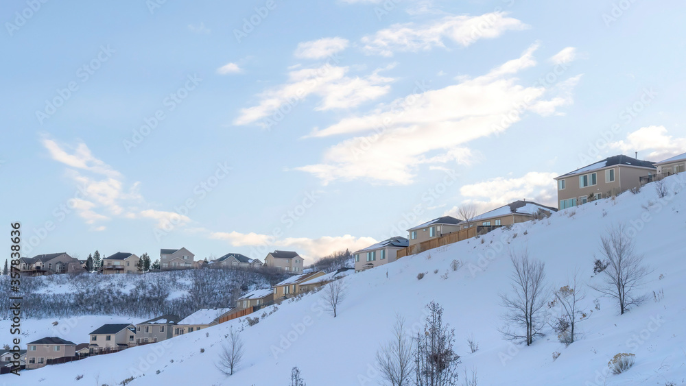 Panorama crop Town situated on incredible slope of Wasatch Mountains with blue sky abckground