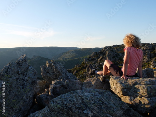 Jeune femme blonde seule face au soleil couchant en montagne tranquillité luxe calme et volupté dans le Parc Naturel régional du Caroux Haut Languedoc