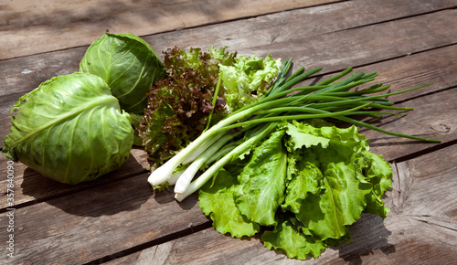 Healthy eating Fresh farm vegetables , salad lola rossaa and lola bianca, green onions, cabbage. Non-GMO Organic Vegetables, 100% Vegan Vegetarian Slimming Diet Wooden Background