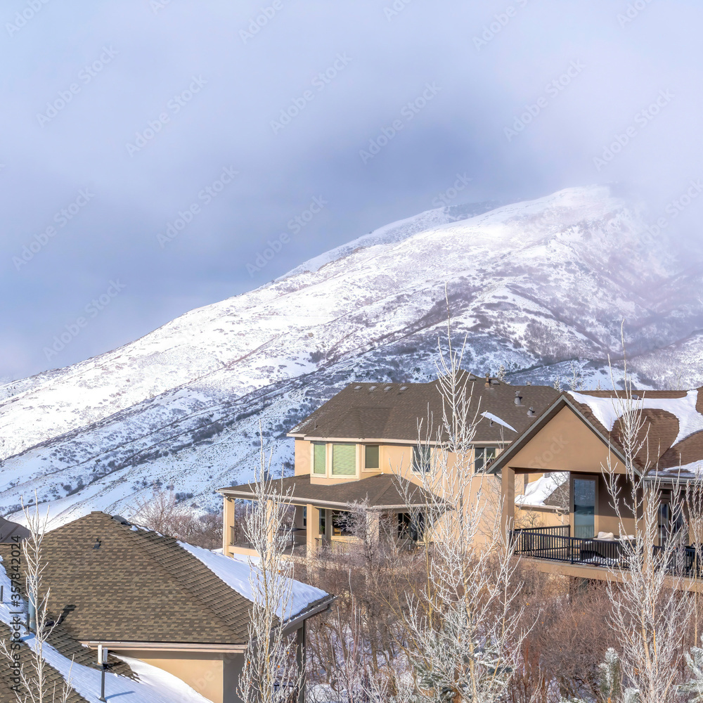 Square Beautiful mountain homes and snow covered slope of Wasatch Mountains in winter