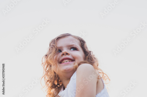 Portrait of cute curly smiling preschool girl