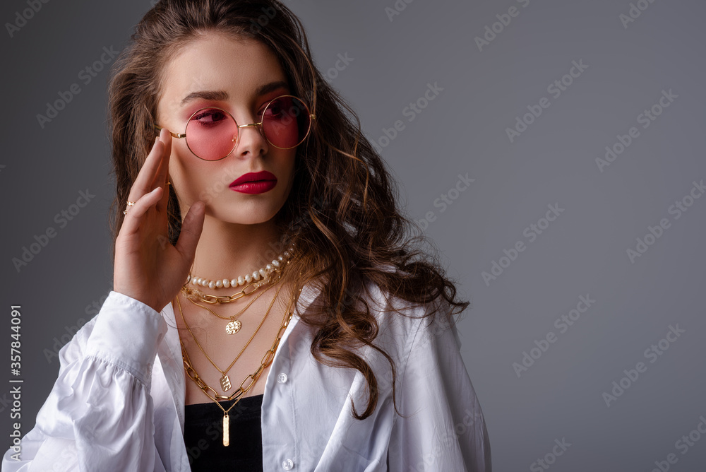 Fashionable model, woman wearing pink color sunglasses, trendy pearl necklace, many golden chains, classic white shirt. Clos up studio portrait. Copy, empty space for text Fashionable model, woman wearing pink color sunglasses, trendy pearl necklace, many golden chains, classic white shirt. Clos up studio portrait. Copy, empty space for text