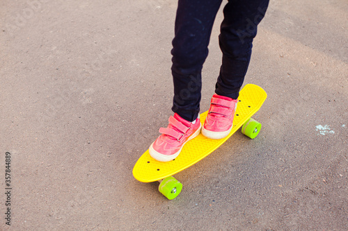 Skateboarder girls legs standing on a skateboard