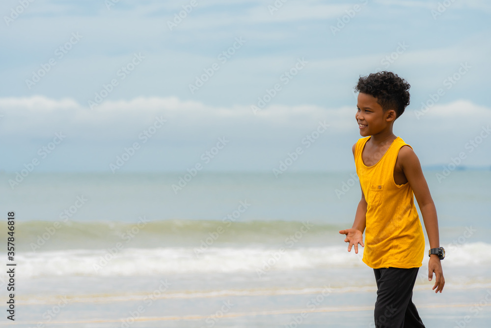 African American boy in yellow tank top smile at the beach African American boy in yellow tank top smile at the beach