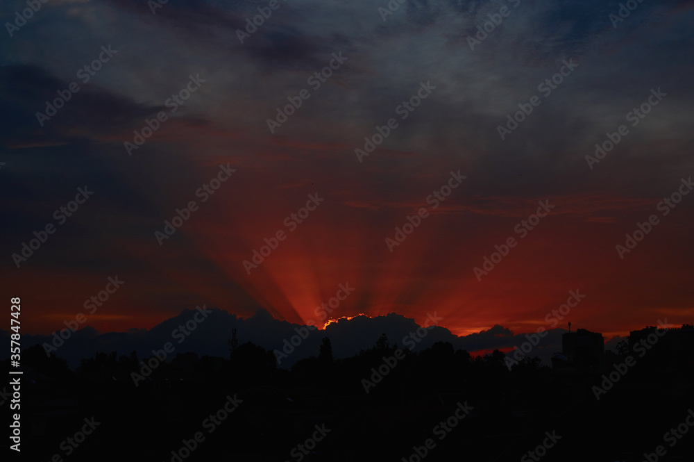 red sunset through clouds on the blue sky horizontally