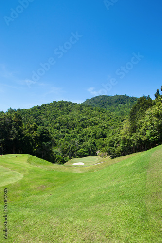 View of golf course in the mountains behind the sky