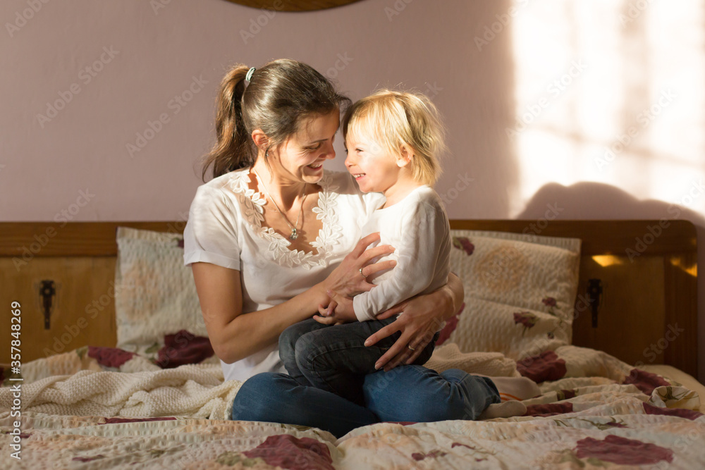 Mom and child, having fun together, reading book and eating croissant Mom and child, having fun together, reading book and eating croissant