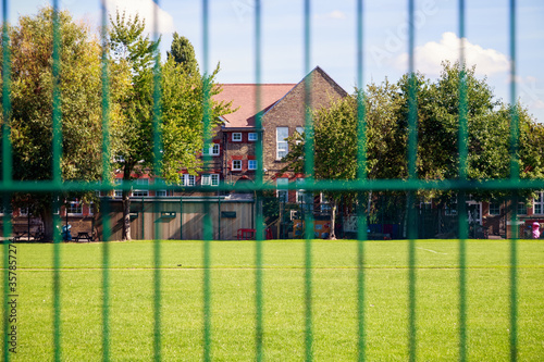 Empty school seen through green fence in Neasden, London photo