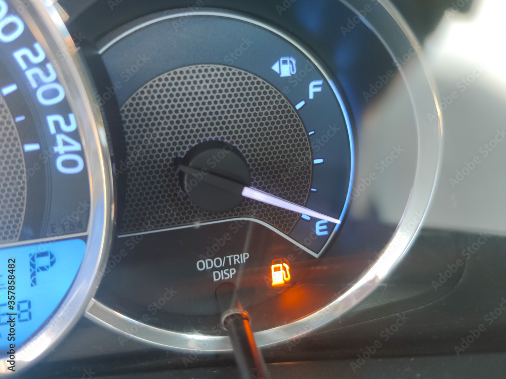 Naklejka premium Fuel gauge showing empty tank with yellow glowing and lit meter