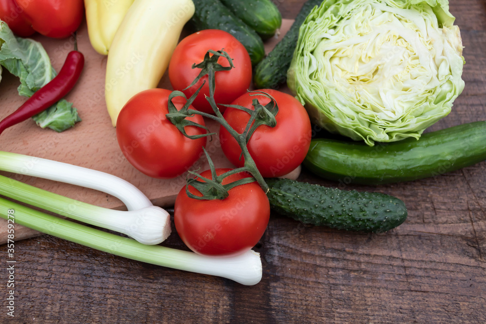 On the table lies a cut head of cabbage, onion peppers, cucumbers and tomatoes. On the table lies a cut head of cabbage, onion peppers, cucumbers and tomatoes.