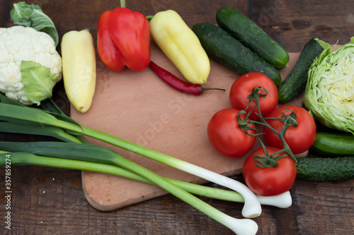 On the table are cabbage, onion peppers, cucumbers and tomatoes.