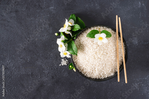 Jasmine rice in a bowl on a black background with copy space