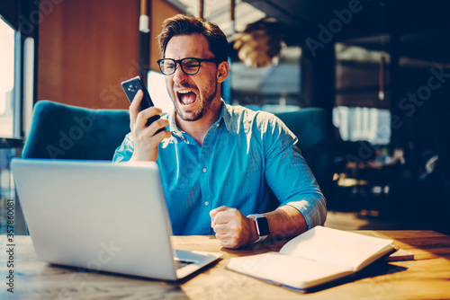 Dissatisfied businessman is angry during telephone conversation photo