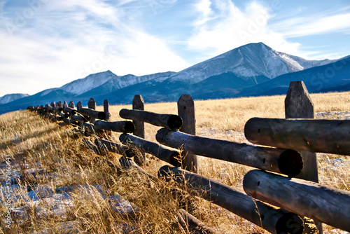 A ranch fence in Colorado with a mountain background.