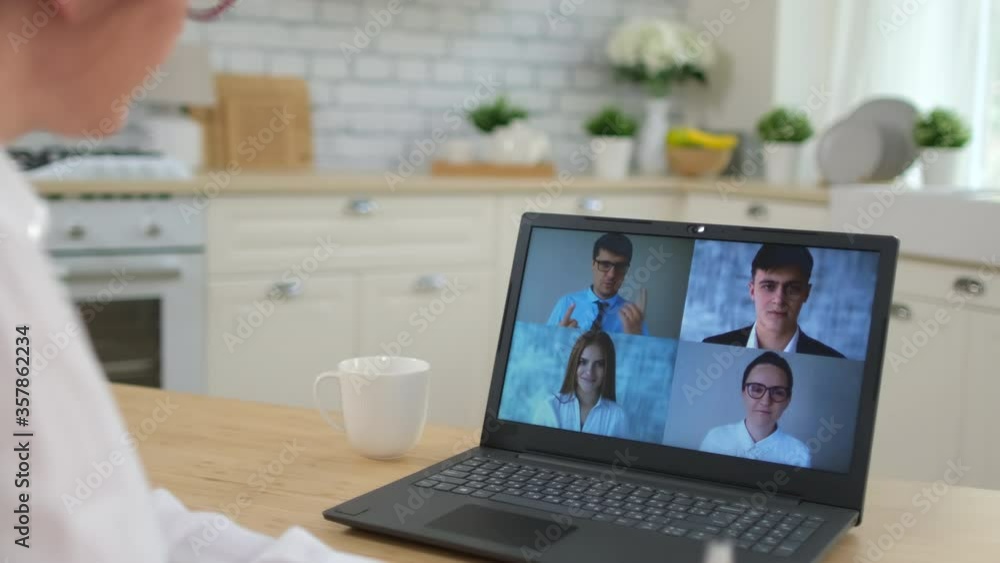 Online working distance learning video call chat conference webinar call webcam meeting concept. Back view woman chatting colleagues team business partner coach laptop home. Coronavirus COVID-19. 4 K Online working distance learning video call chat conference webinar call webcam meeting concept. Back view woman chatting colleagues team business partner coach laptop home. Coronavirus COVID-19. 4 K