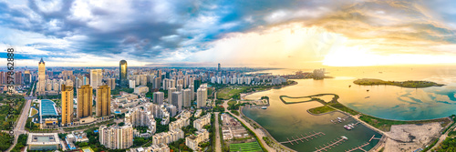 China Hainan Haikou Cityscape in the Binhai Avenue CBD Area, with Landmark Buildings , Sea Port and Evergreen Park View During Sunset. Aerial View..
