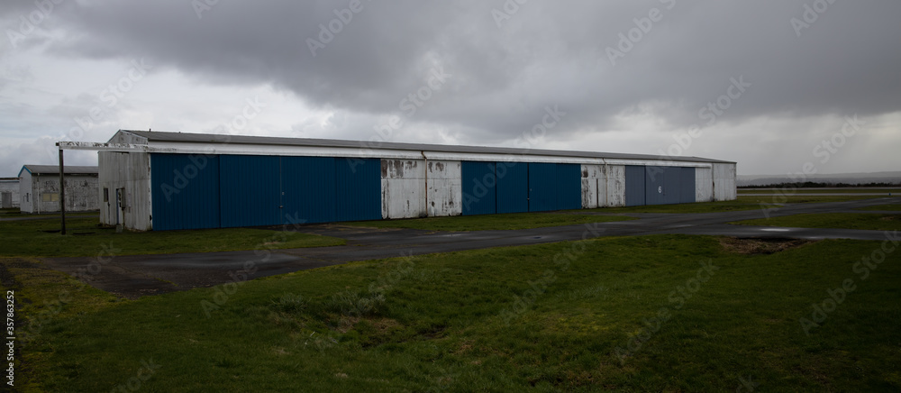 Obraz premium Abandoned airport hanger with large, locked storage rooms