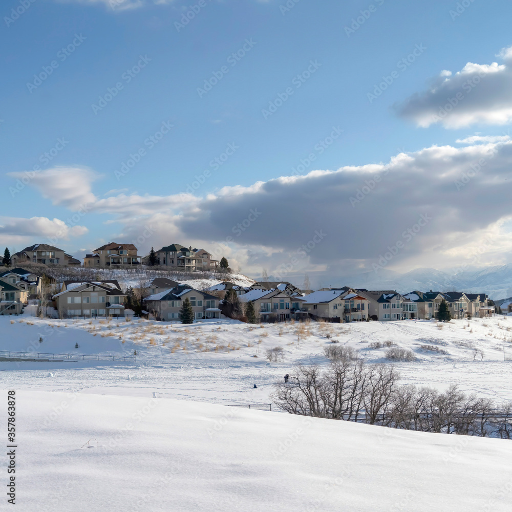 Square frame Wasatch Mountain in winter with houses on sunlit acres of snow covered terrain