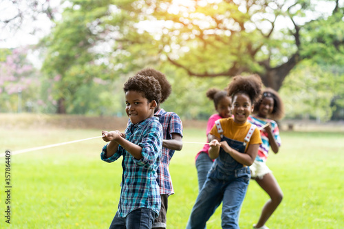 Group of Children having fun playing tug of war at the park, Group of children in a field trips. Sport and Field trip concept