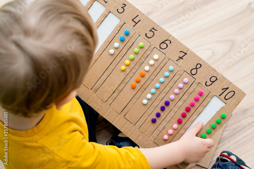 Preschool educational aid for kindergartens and home school. Put correct strap with balls of cotton wool to assigned cavity with number. Children early learning montessori kit for intelligence.