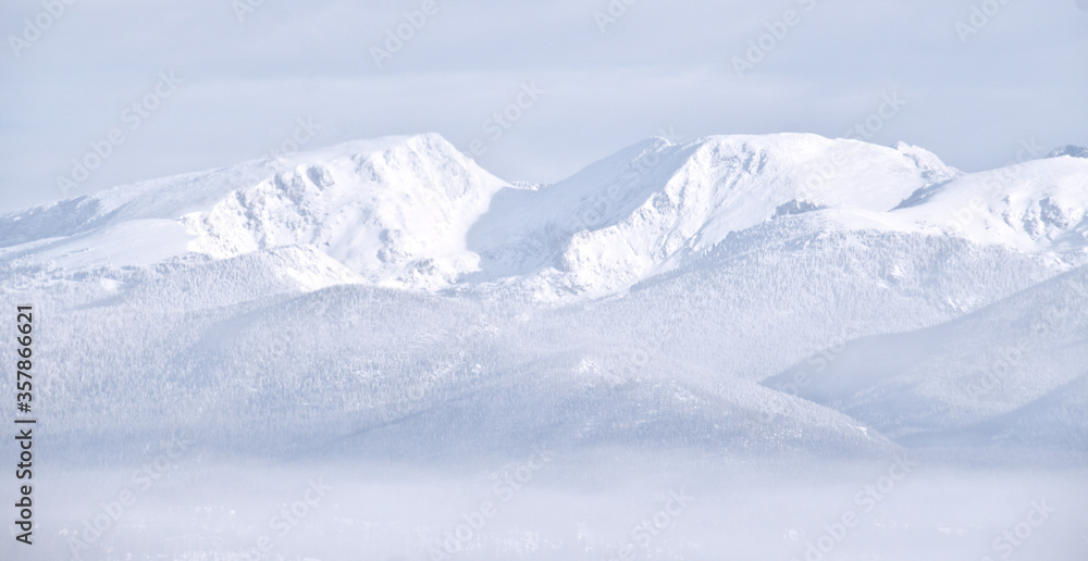 Fototapeta premium Snow covered white mountains in Colorado with fog