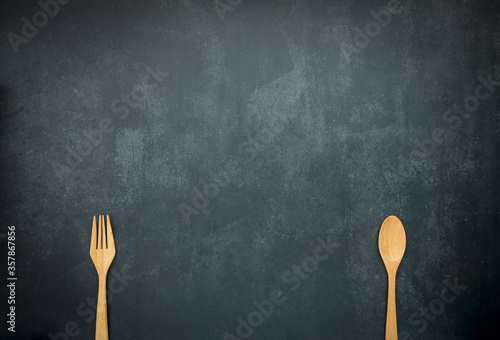 wooden spoon and fork on dark blue background with copy space