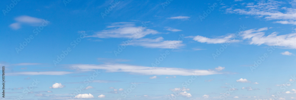 Panorama of blue sky with single white clouds Panorama of blue sky with single white clouds