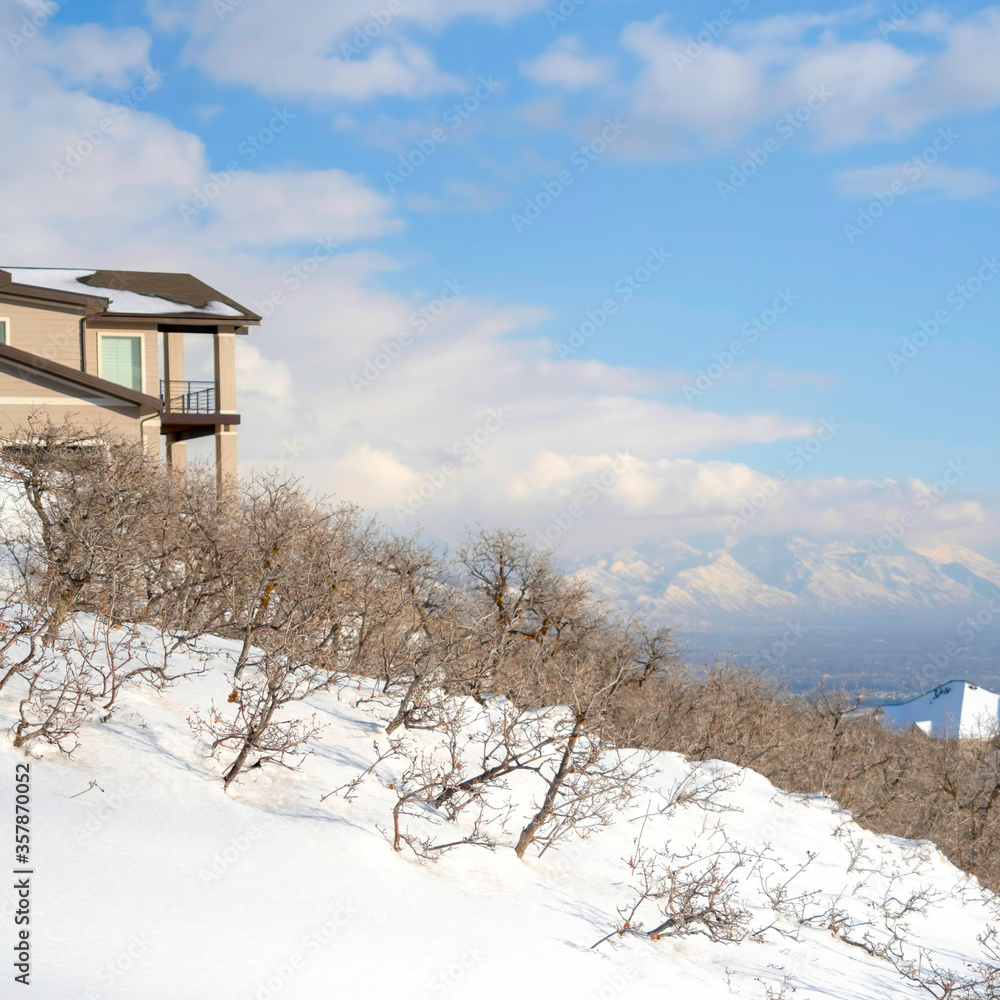 Square frame Mountainside home overlooking the valley and Wasatch Mountains under cloudy sky Square frame Mountainside home overlooking the valley and Wasatch Mountains under cloudy sky