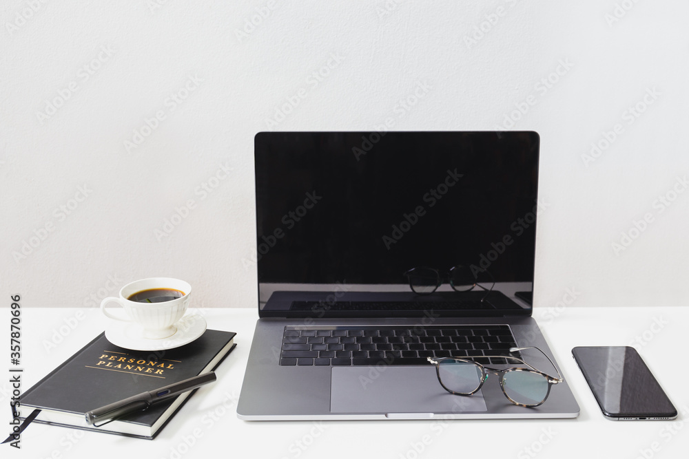 Mockup of laptop with eyeglasses and cell phone, coffee cup over notebook on white table. Mockup of laptop with eyeglasses and cell phone, coffee cup over notebook on white table.