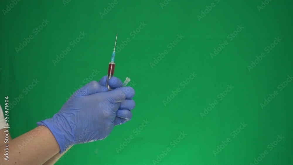hand in a medical glove and a syringe with medicine on a green screen, preparation for injection hand in a medical glove and a syringe with medicine on a green screen, preparation for injection