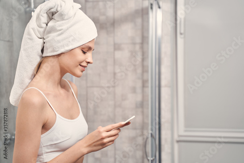 Woman staring at her smartphone in the bathroom
