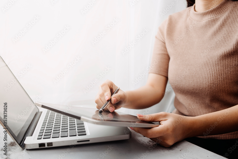 Fototapeta premium businesswoman hand using smart phone, tablet payments and holding credit card online shopping, omni channel, digital tablet docking keyboard computer at office in sun light