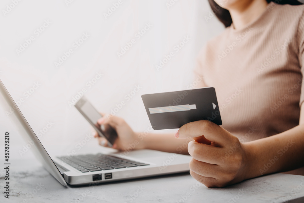 businesswoman hand using smart phone, tablet payments and holding credit card online shopping, omni channel, digital tablet docking keyboard computer at office in sun light businesswoman hand using smart phone, tablet payments and holding credit card online shopping, omni channel, digital tablet docking keyboard computer at office in sun light