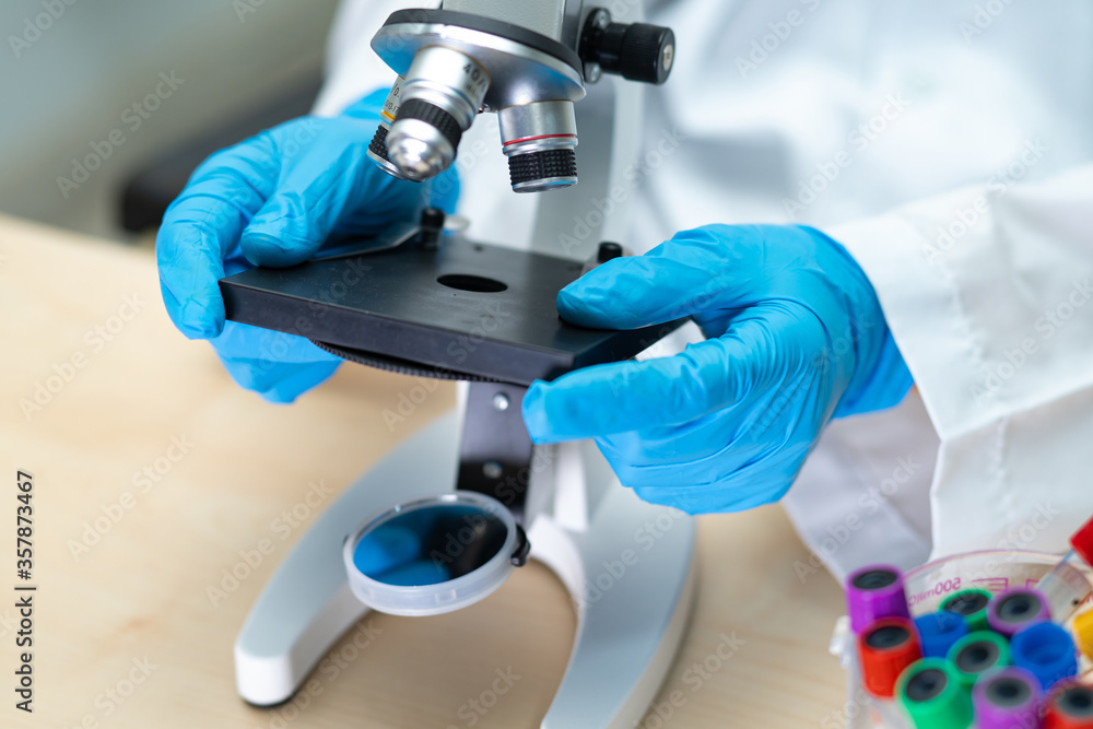 Asian scientist biochemist or microbiologist working research with a microscope in laboratory. For protect outbreak Coronavirus Covid19, bacteria and germs. Asian scientist biochemist or microbiologist working research with a microscope in laboratory. For protect outbreak Coronavirus Covid19, bacteria and germs.