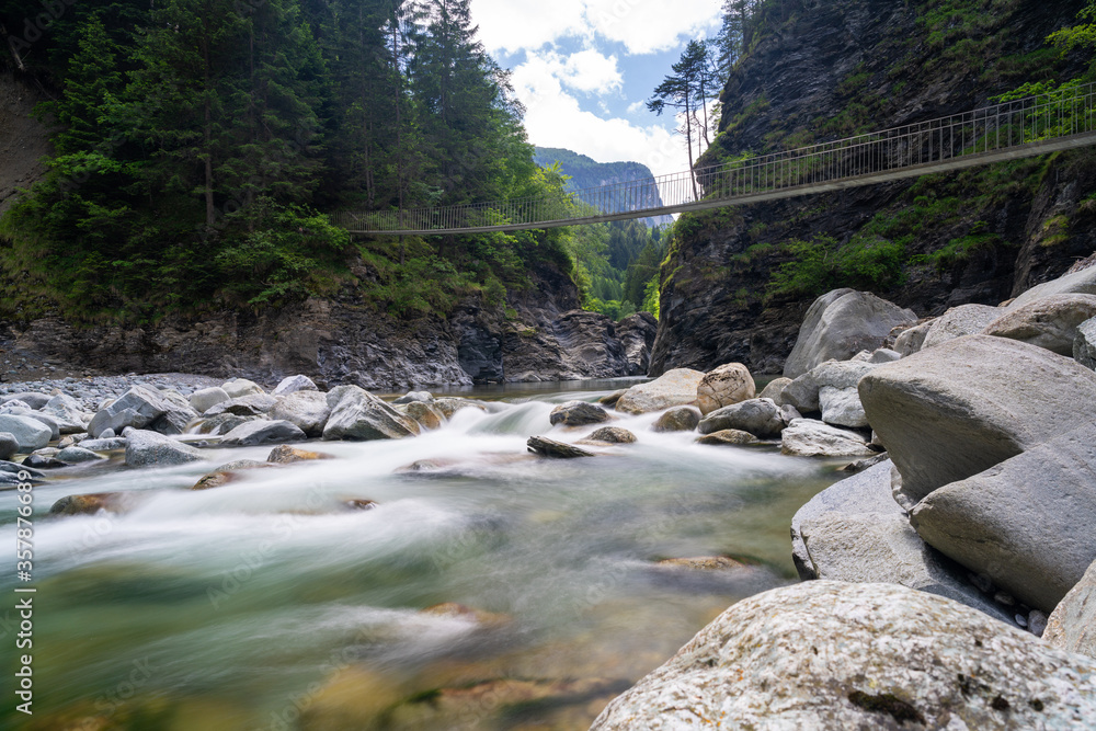 Obraz premium wooden suspension bridge crossing the Rhine River in the Viamala Gorge in the Swiss Alps