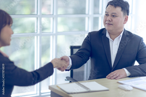 Wallpaper Mural Two Asian business wears a black suit and hand in hand with a partner and smile confidently.  Asian business concept. Torontodigital.ca