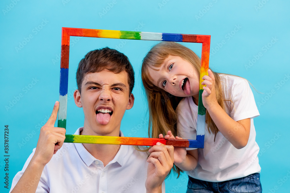 A 5 year old Girl And A Teenage Boy Look At The Camera Through A a-5-year-old-girl-and-a-teenage-boy-look-at-the-camera-through-a