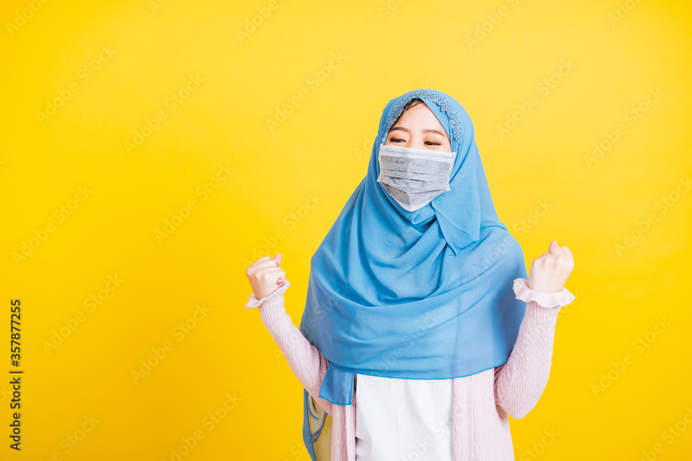 Asian Muslim Arab, Portrait of happy beautiful young woman Islam wear veil hijab and face mask protect raise hands glad excited cheerful after recovering from illness coronavirus isolated yellow Asian Muslim Arab, Portrait of happy beautiful young woman Islam wear veil hijab and face mask protect raise hands glad excited cheerful after recovering from illness coronavirus isolated yellow