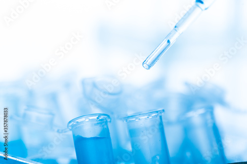 microbiological pipette in the genetic laboratory. study of a virus or vaccination. blue tinted.