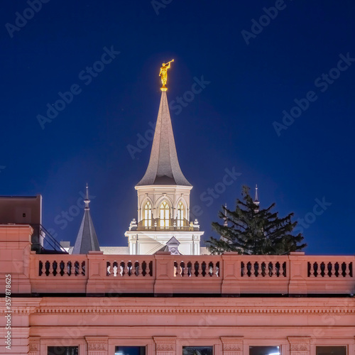 Square frame Provo City Center Temple with statue of angel and spire against blue evening sky
