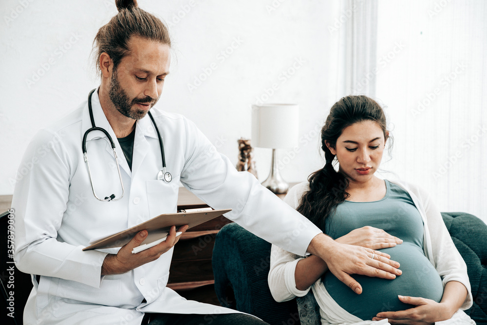 Handsome doctor used the stethoscope for pregnancy to check readiness by appointment. Being maternity and parenthood concept. Antenatal care concept. Handsome doctor used the stethoscope for pregnancy to check readiness by appointment. Being maternity and parenthood concept. Antenatal care concept.