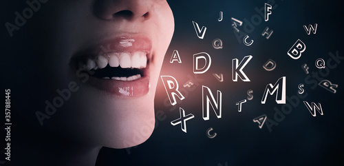 фотографія Smiling woman and letters on dark background, closeup