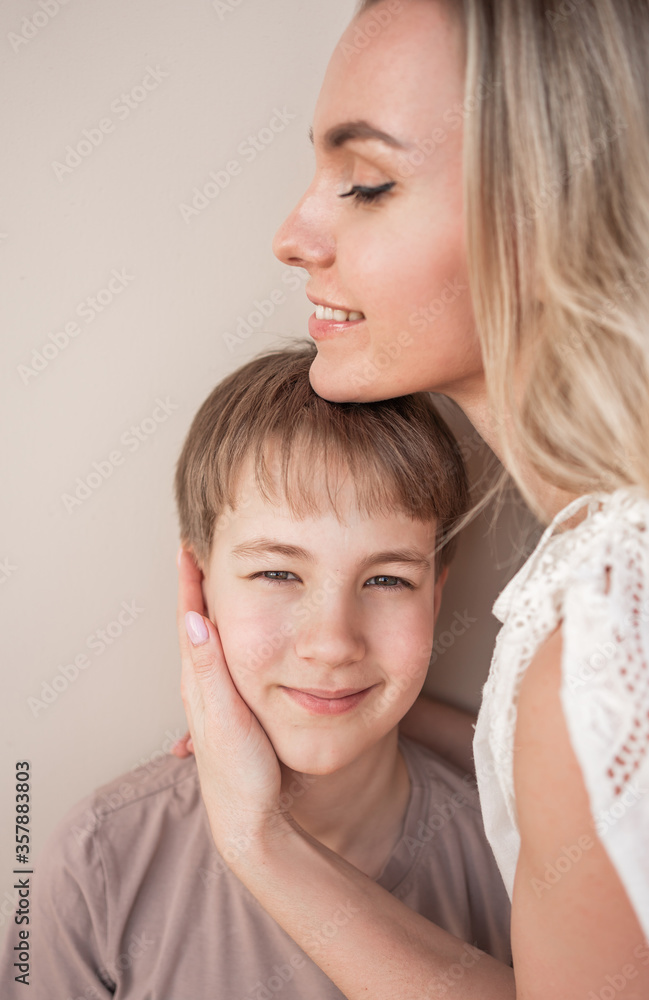 Mom hugs with tenderness and love the son of a teenager. Portrait. Mom hugs with tenderness and love the son of a teenager. Portrait.