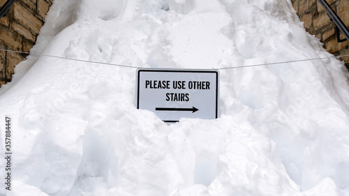 Panorama frame Snowed in stairway with sign that reads Please Use Other Stairs in winter